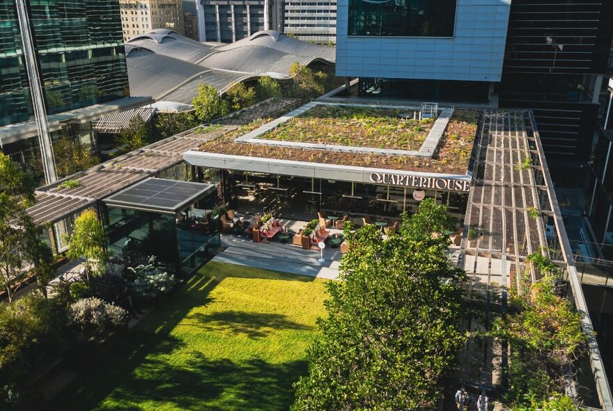 Rooftop bar and outdoor park area at The Quarterhouse, with Melbourne city buildings in the background.