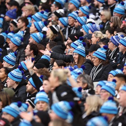 Crowd of seated AFL fans wearing Big Freeze branded beanies.