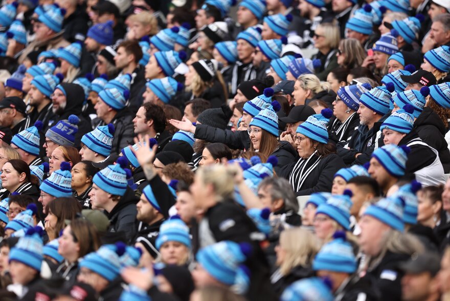 Crowd of seated AFL fans wearing Big Freeze branded beanies.