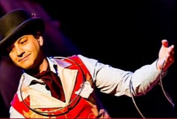 Performer wearing a hat and waistcoat, with rope.