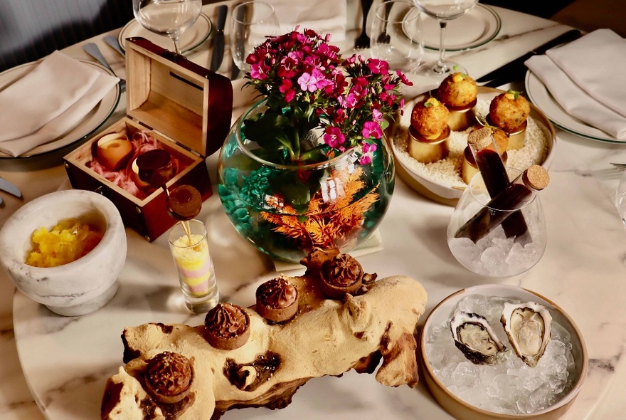 Restaurant table set with an assortment of dishes including oysters.