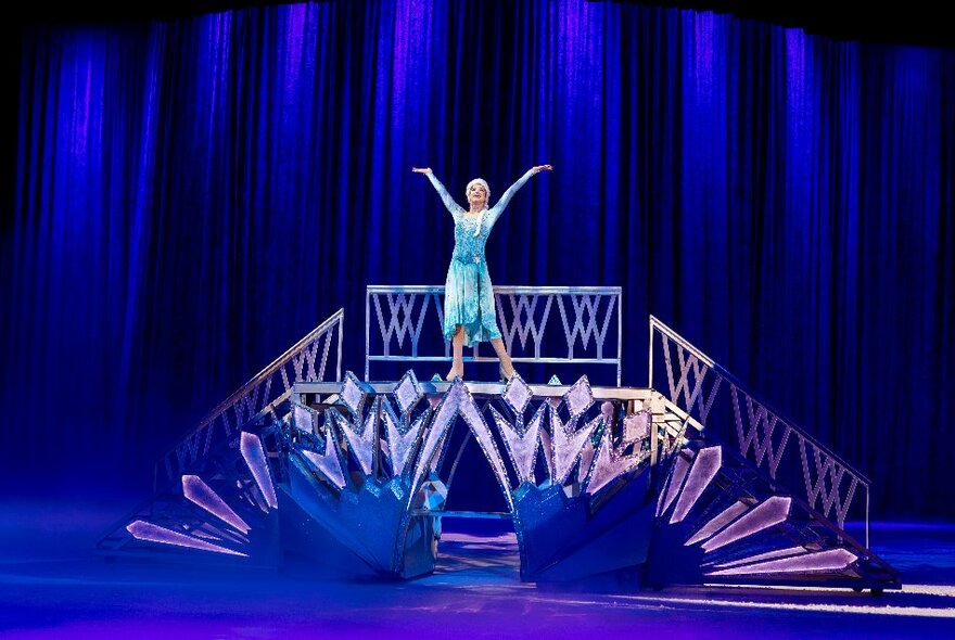 Elsa from Frozen, singing on a staircase during Disney on Ice.