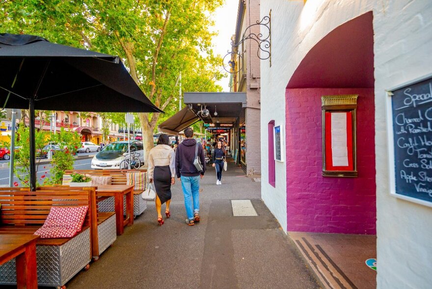 A city street with people walking outside of a venue
