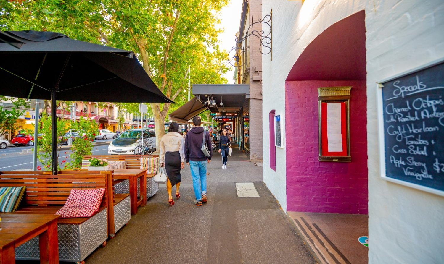 A city street with people walking outside of a venue