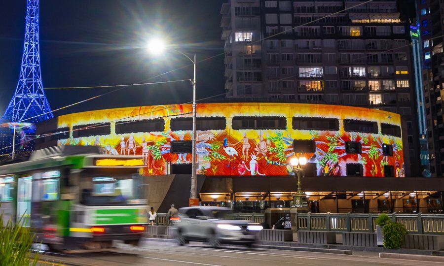 Projections on Hamer Hall at night, with traffic going past.