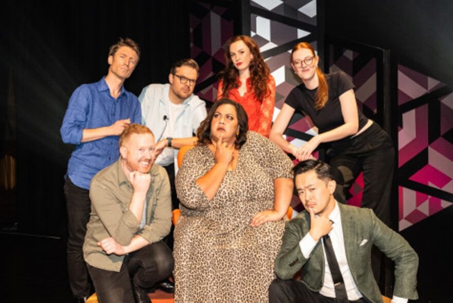 A group of comedians posing on a stage.