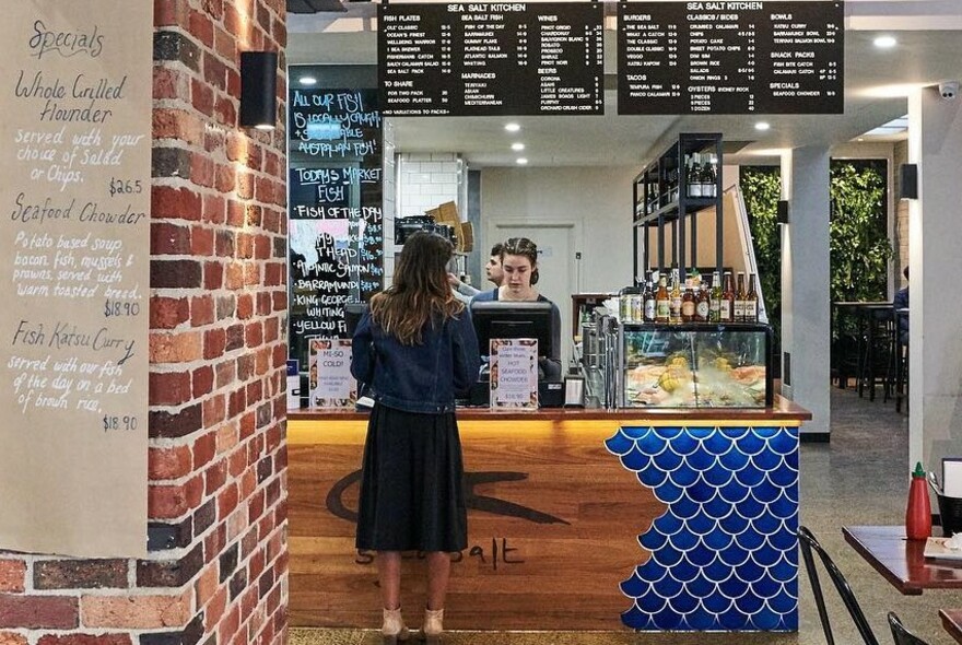 Woman being served at counter of Sea Salt Kitchen.