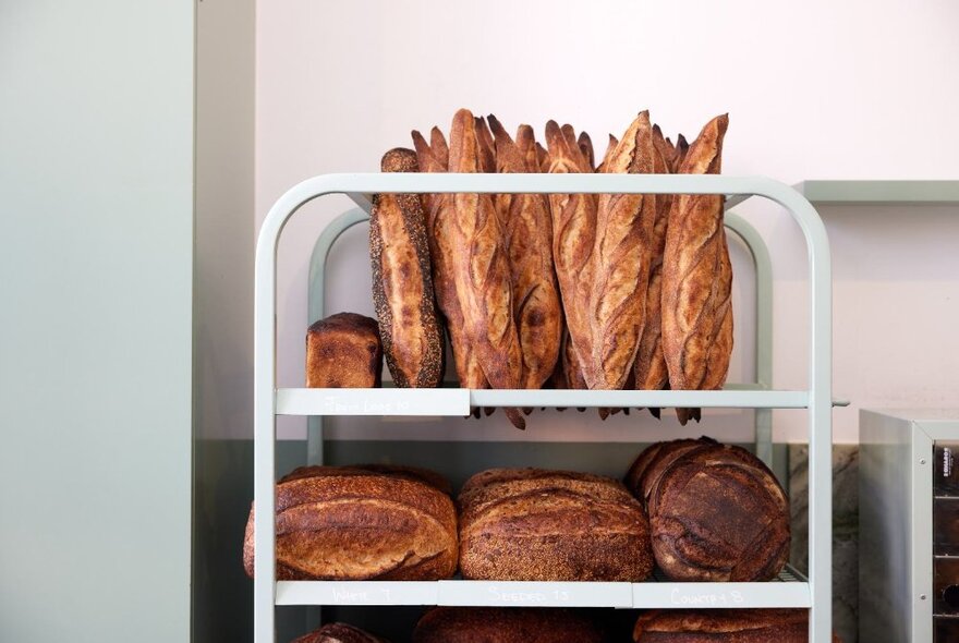 Mint green trolley filled with baguettes and loaves.