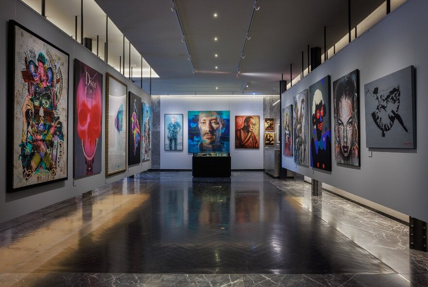 Inside an art gallery space with large artworks on the walls.