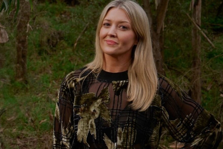 Portrait of podcast host, Lauren Taylor looking at the camera with a slight smile, in a bushland setting.