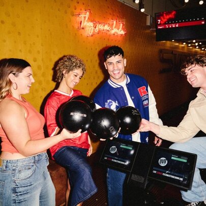 A group of four friends holding bowling balls.