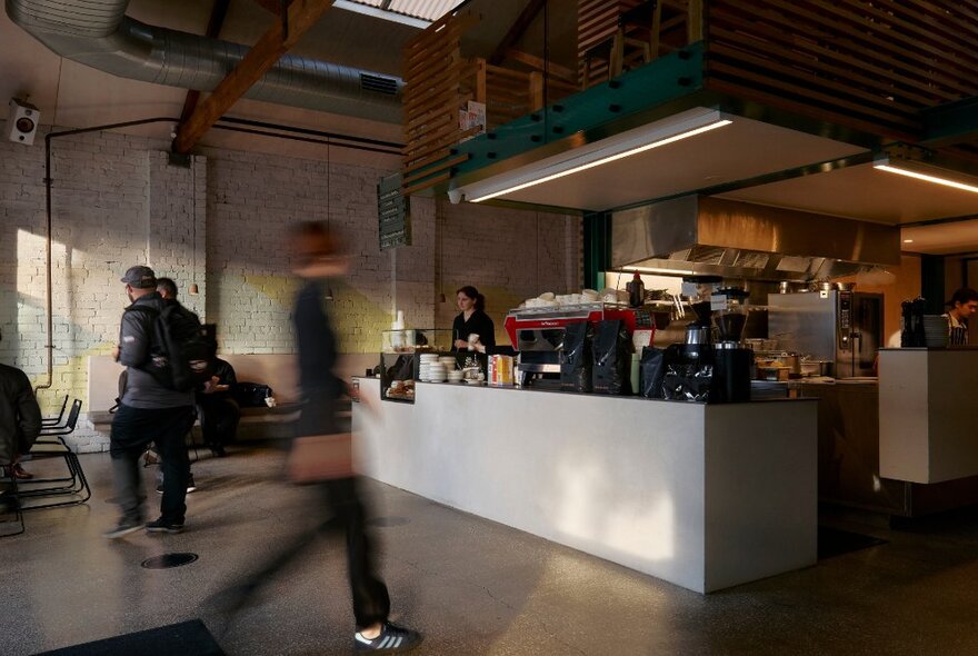 People walking around inside Code Black cafe, a large industrial style cafe. 