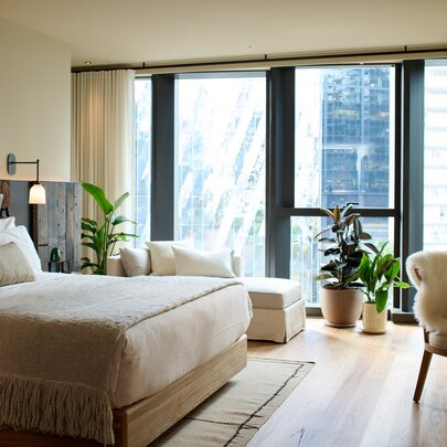 A hotel room with a rustic interior design and a large floor-to-ceiling window.