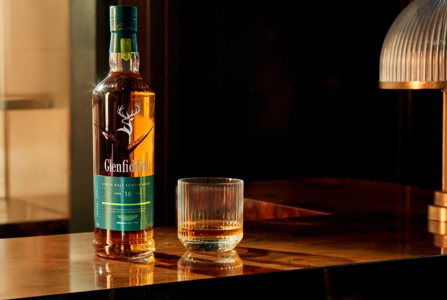 A Glenfiddich whisky bottle and container.