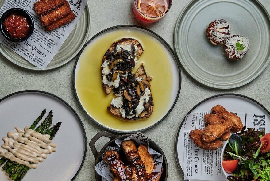 Looking down at a selection of dishes of food on a table top.