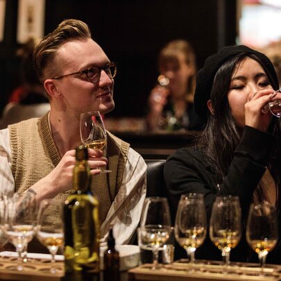 A couple sampling whisky's as part of a tasting flight.