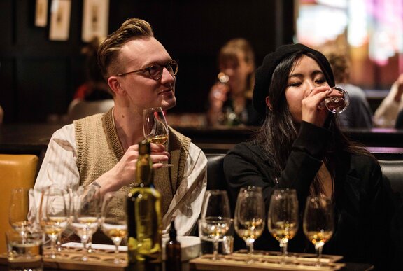 A couple sampling whisky's as part of a tasting flight.
