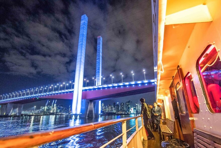 Bolte Bridge at night, with a close up of a boat approaching it.