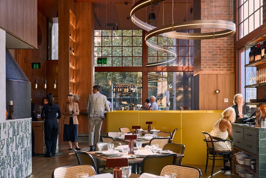 A bright restaurant with high ceilings and a winding light installation.