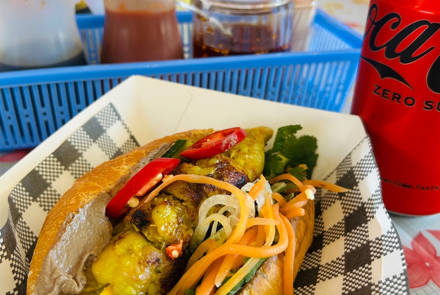 A Vietnamese bun in a serviette-lined box.