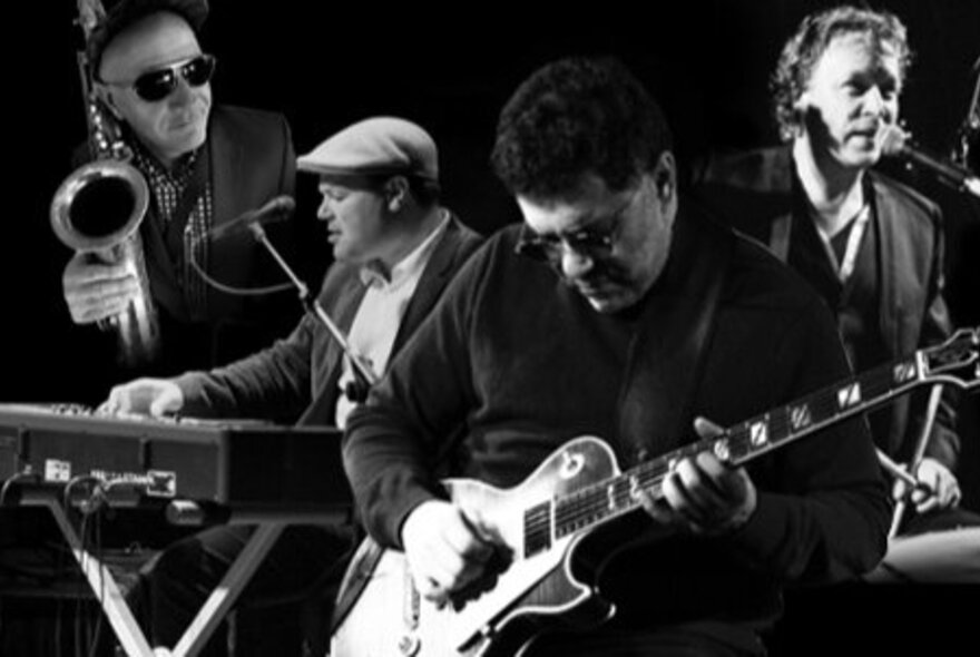 Jazz musicians performing with guitarist, keyboards, saxophone and percussion.