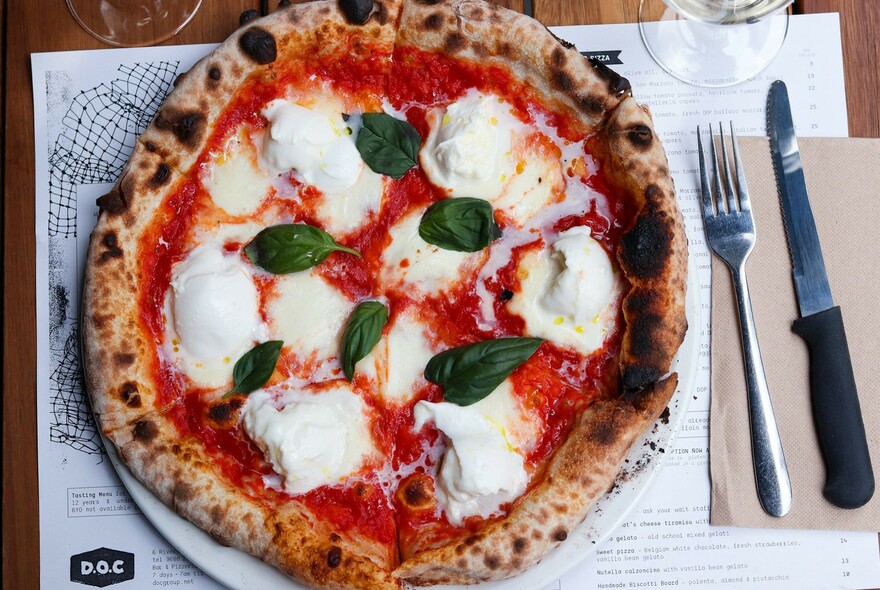 Buffalo mozzarella pizza with basil leaves.