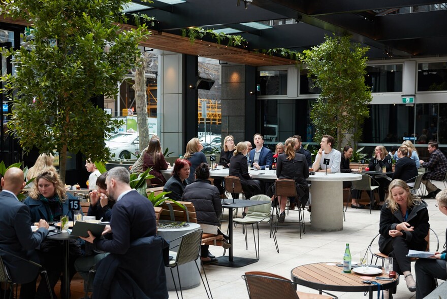 Outdoor dining area filled with people at tables.