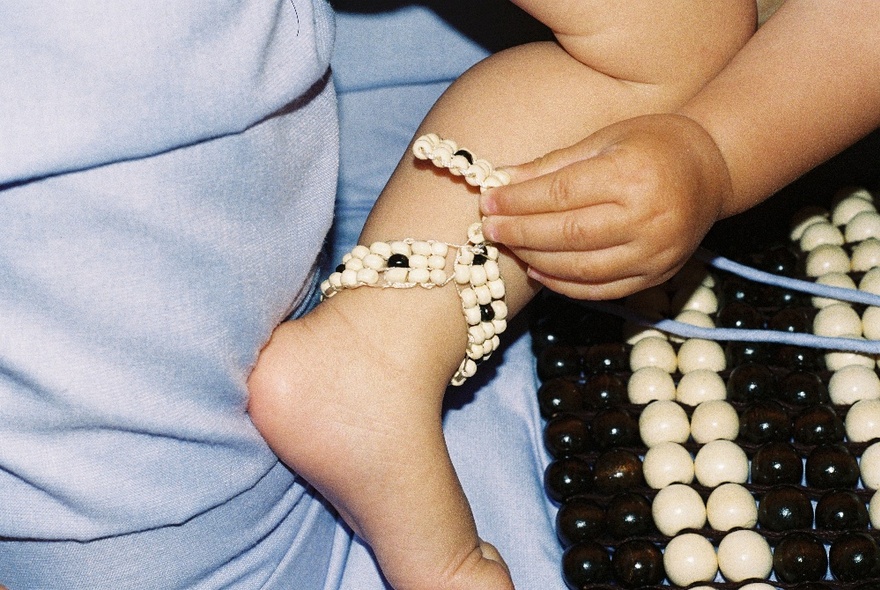 A selection of beaded materials, one on a child's leg. 