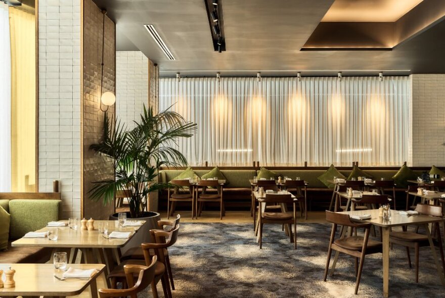 Interior of the Little Collins St Kitchen, with muted neutral colours, and tables set for service, inside the Sheraton Melbourne Hotel.