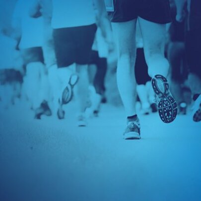 A parade of legs wearing trainers in a blue background.