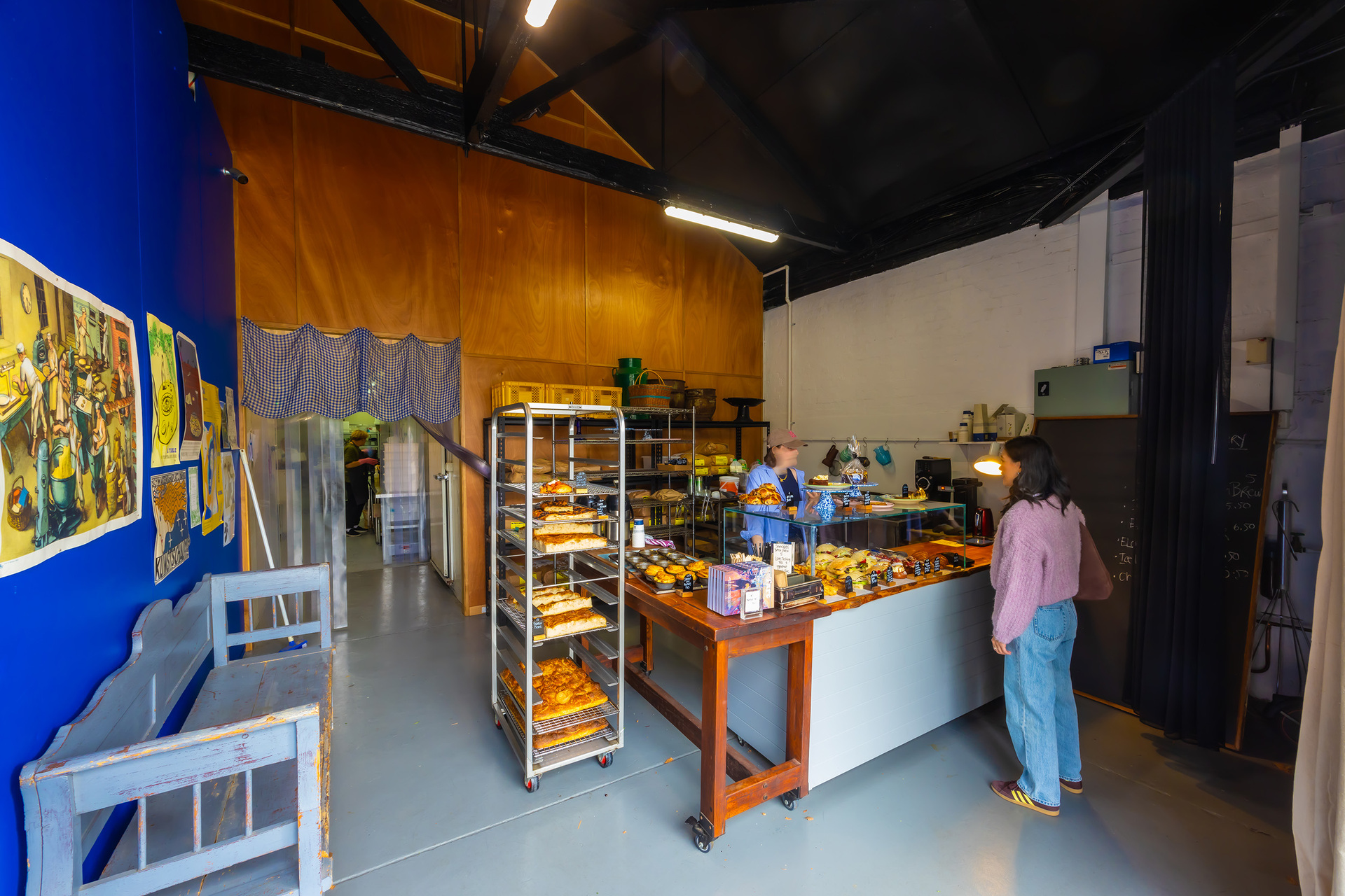 A person is ordering baked goods inside a bakery