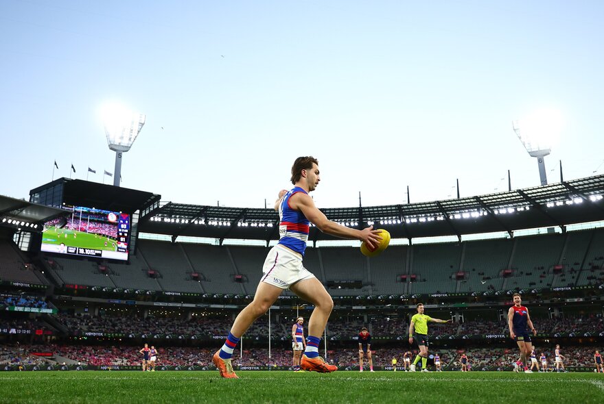 Western Bulldogs AFL football player with the ball during a match.