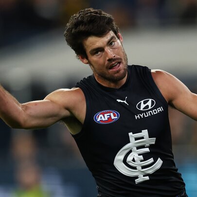 A Carlton AFL player straight after a goal with finger raised in the air. 