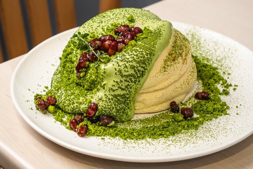 Souffle-style fluffy pancakes with pistachio cream and a dusting of cocoa.