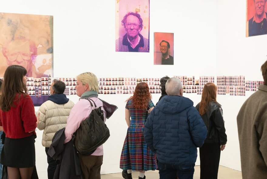 People viewing an exhibition in a busy gallery space.