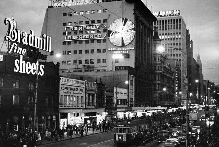 A black and white photo of a city street at night