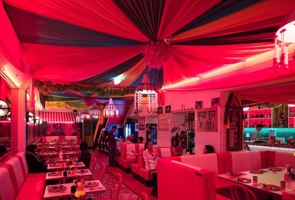 Inside an Indian restaurant with red fabric draped on the ceiling