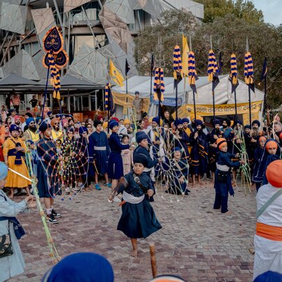 A Sikh festival in Federation Square with people in traditional costumes and flags. 