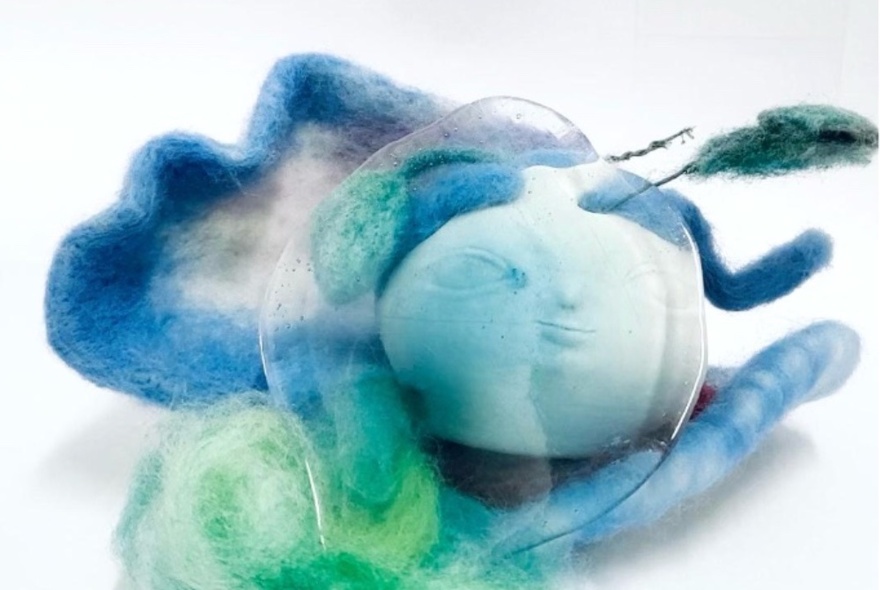 A fabric art piece in tones of blue and green.