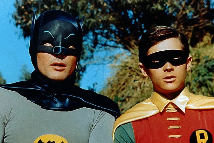 A still image from the 1960s Batman TV series showing Batman and Robin looking blankly ahead. 