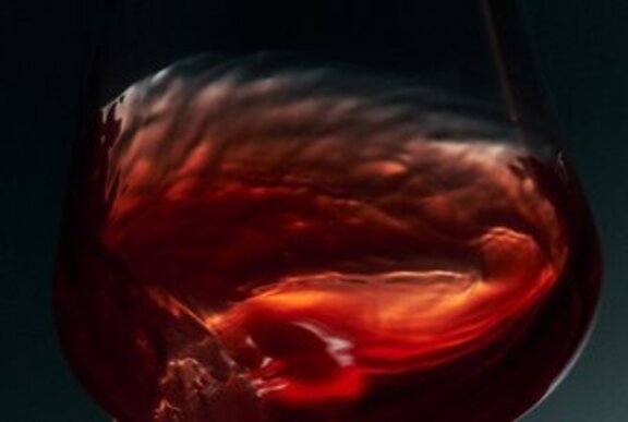 Red liquid swishing in a wine glass.