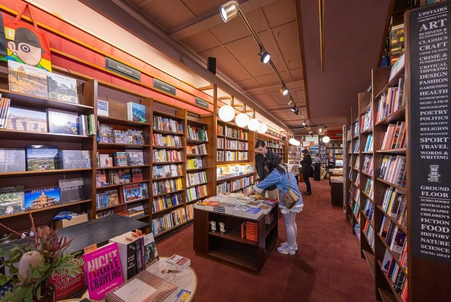 Man and woman shopping inside Hill of Content book shop. 