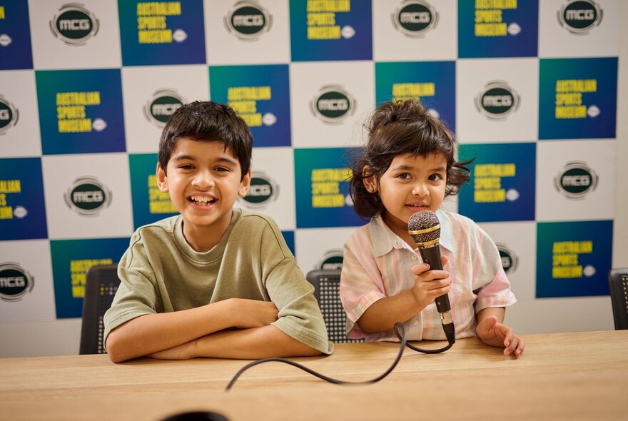 Two kids in the commentary box at the MCG.