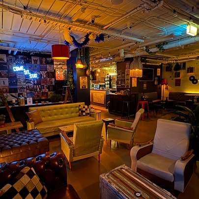 Venue with couches, armchairs and picture frames on the walls.
