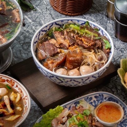 Bowls of Thai noodles on a cafe table.