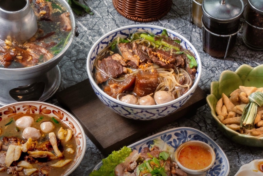 Bowls of Thai noodles on a cafe table.