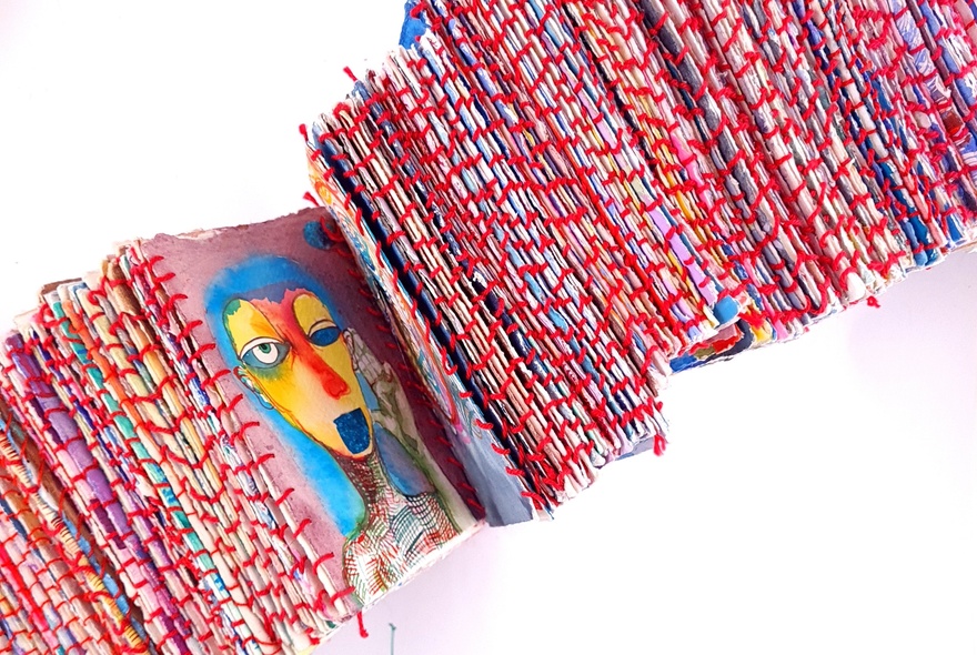 Red-spined concertina books featuring an abstract illustration of a face.