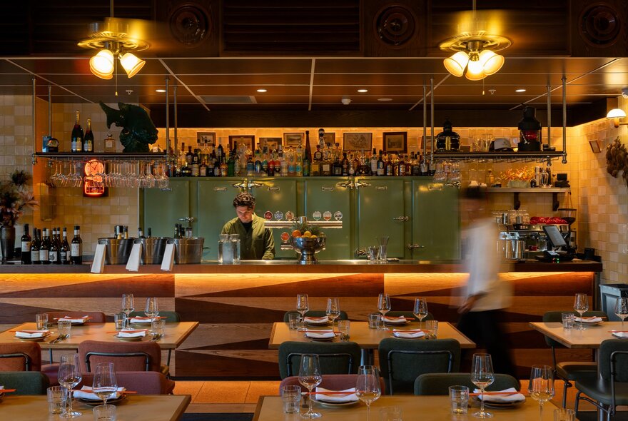 Cosily lit dining area with table seating and large bar area.