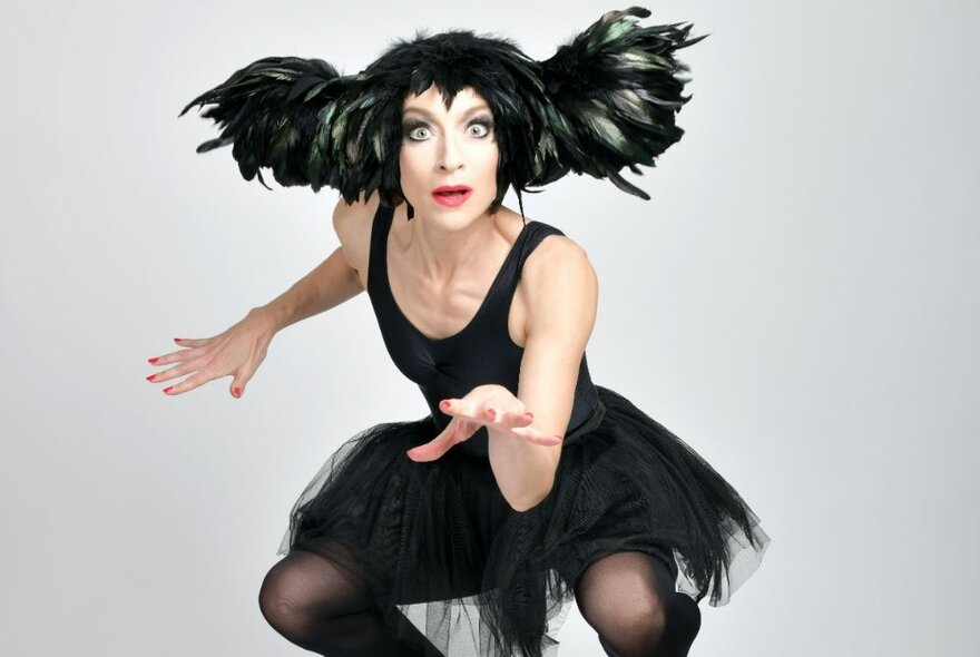 UK performer, Sarah-Louise Young, dressed in a black tutu and wig, performing in character as Kate Bush.