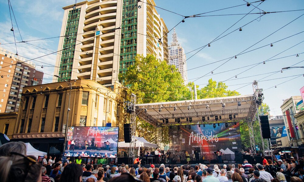 Crowds looking at a festival stage in the city.